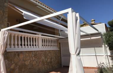 Toldo verde clásico en balcón de Torredembarra